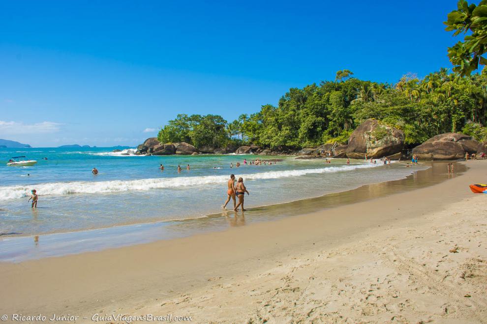 Imagem de crianças e adultos no mar.